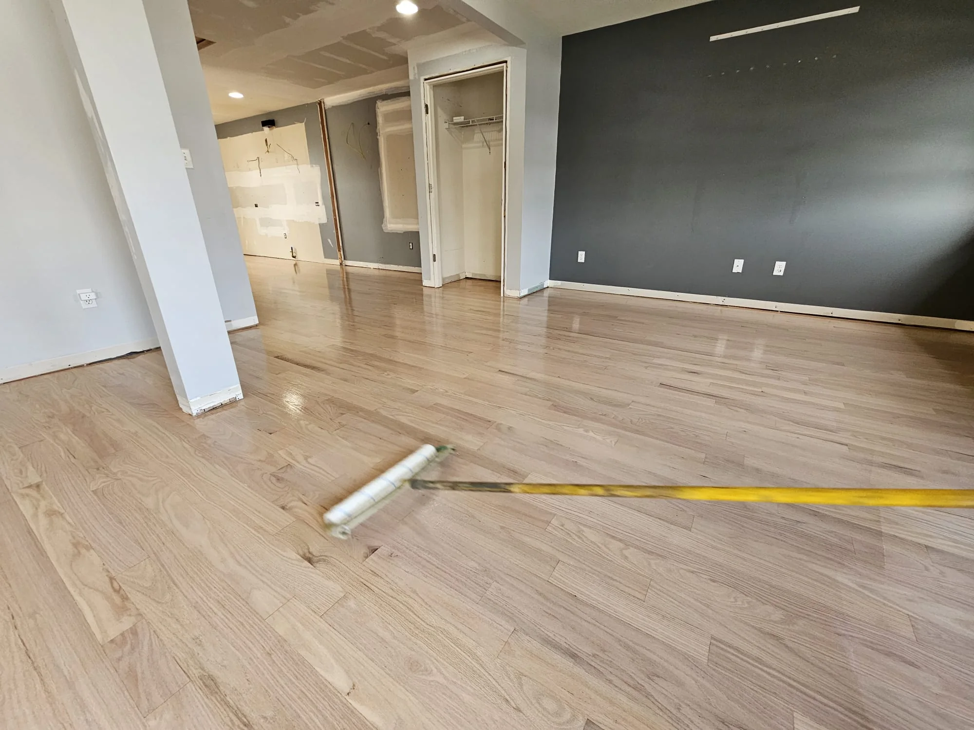 Finish being applied to a freshly sanded oak floor